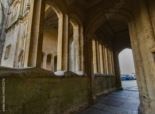 Medieval stone arch walkway. Historical Flagstone flooring leads the way. Contrasting shadows cast beneath the aches. Copy space