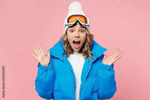Snowboarder surprised woman wear blue suit goggles mask hat ski padded jacket spend extreme weekend spread hands say wow isolated on plain pastel pink background Winter sport hobby trip relax concept