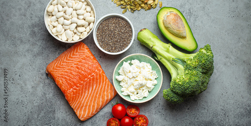 Selection of healthy food products if a person have diabetes: salmon fish, broccoli, avocado, beans, vegetables, seeds on grey background from above. Healthy diabetes diet