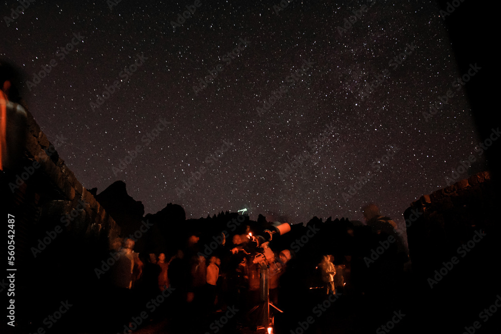 Mountains at night and stars in the sky, shooting stars and planets in the sky. Noisy photo at long exposure. People look at the stars through a telescope, stargazing Mountains at night and stars in the sky, shooting stars and planets in the sky. Noisy photo at long exposure. People look at the stars through a telescope, stargazing