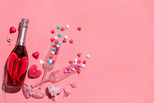 Holiday background with bottle of champagne, two glasses and candy. Romantic date on Valentine's day.