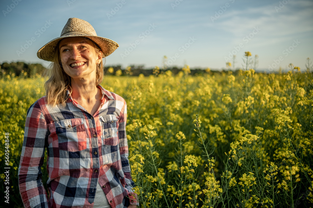 ortrait of a girl smiling in a rapeseed field at sunset
