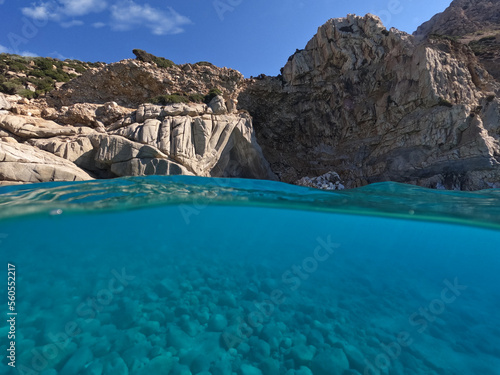 Underwater split photo of paradise exotic volcanic white rock island pebble beach with crystal clear turquoise sea in Caribbean destination island forming a blue lagoon