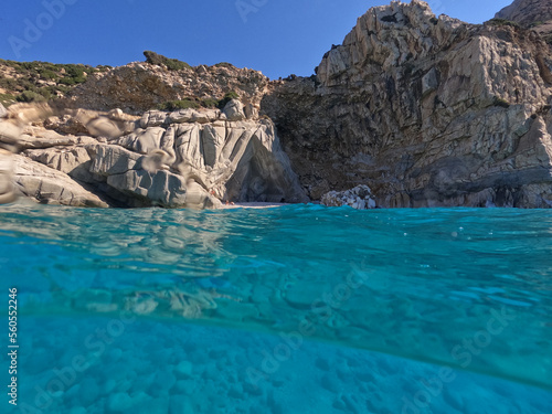 Underwater split photo of famous paradise turquoise pebble beach of Seychelles in island of Ikaria, Aegean sea, Greece