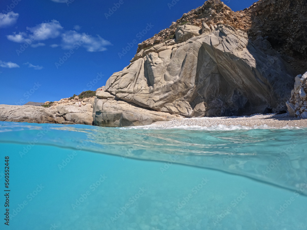 Fototapeta premium Underwater split photo of paradise exotic volcanic white rock island pebble beach with crystal clear turquoise sea in Caribbean destination island forming a blue lagoon