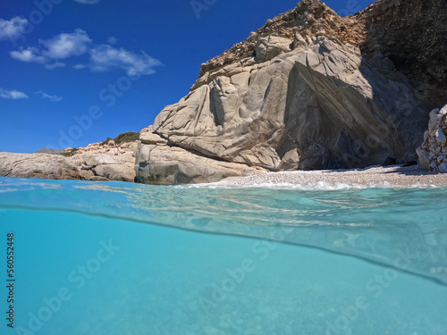 Underwater split photo of paradise exotic volcanic white rock island pebble beach with crystal clear turquoise sea in Caribbean destination island forming a blue lagoon