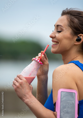 Woman drinking smoothie after jogging outdoor