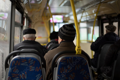 People on bus. Seating on public transport. Seats in interior of bus. Passengers in transport.