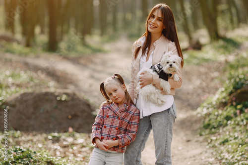 Mother with daughter in a spring forest with dog