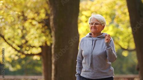 Senior grey-haired woman jogging in the park . High quality photo