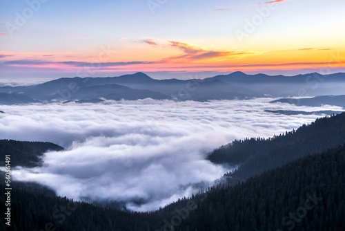 Panorama with sunrise. Landscape with high mountains. Morning fog. Natural scenery.