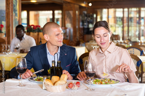 Cheerful man and woman enjoying evening meal in restaurant, having date