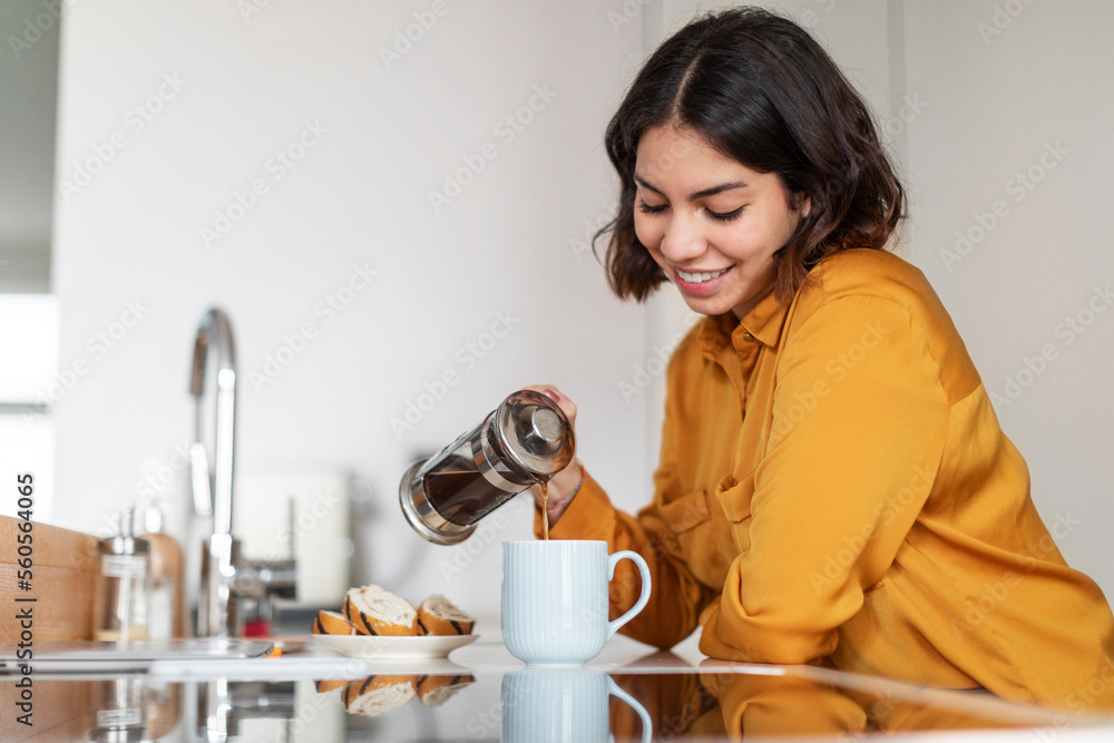 Closeup Shot Of Young Smiling Arab Woman Pouring Morning Coffee To Cup Closeup Shot Of Young Smiling Arab Woman Pouring Morning Coffee To Cup