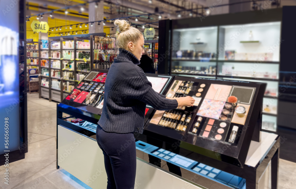 Woman buying make up at cosmetics section in store. choosing cosmetics, perfumes, creams and shampoos, Using tester. Woman buying make up at cosmetics section in store. choosing cosmetics, perfumes, creams and shampoos, Using tester.