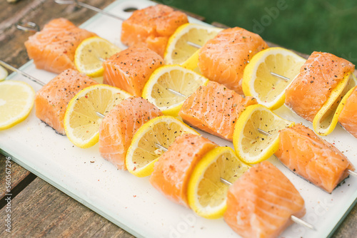 Grilled salmon and lemon skewers on a smokey bbq during a summer day  (ID: 560567296)