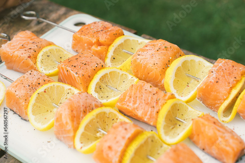Grilled salmon and lemon skewers on a smokey bbq during a summer day  (ID: 560567297)