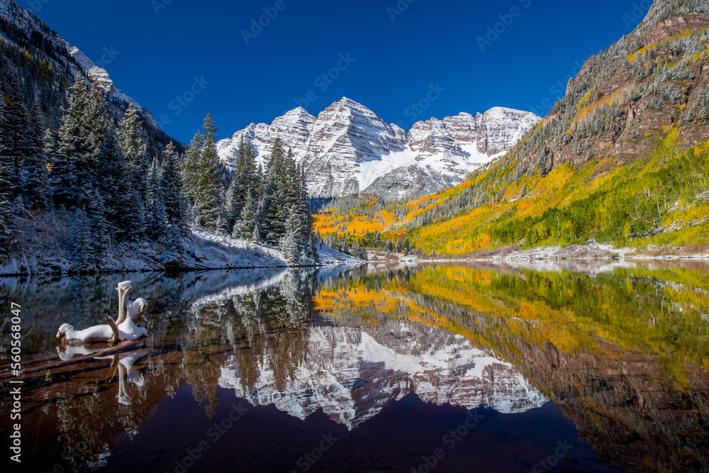 The Maroon Bells Reflected in a Lake as Autumn changes to Winter