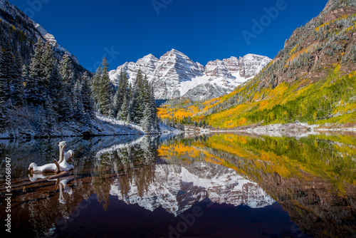 The Maroon Bells Reflected in a Lake as Autumn changes to Winter