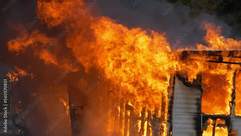 Intense house fire burns a trailer home until there is nothing left. Close up slow motion shot of huge flames engulfing a small building. Intense house fire burns a trailer home until there is nothing left. Close up slow motion shot of huge flames engulfing a small building.