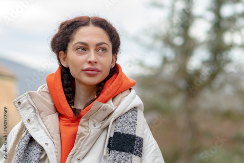 Street portrait of a beautiful woman 25-30 years old with enlarged lips on a blurry neutral background of nature.