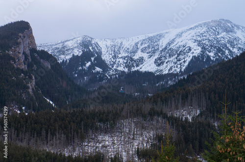 Winter mountain landscape with the image of the Tatra Mountains on the border of Poland and Slovakia - Kasprowy Wierch mountain road with snow lying on a slope. Zakopane, Poland.