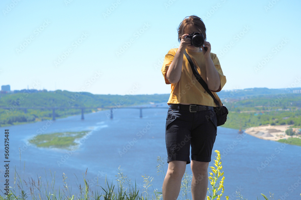 Girl with a camera in the summer on the street in sunny weather.