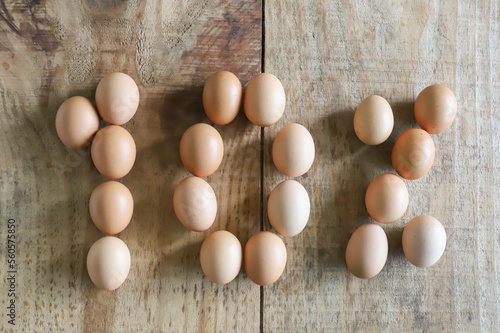 10% numeral written with chicken eggs arranged on a rustic pine wooden table, ideal for use of numerals in easter season.