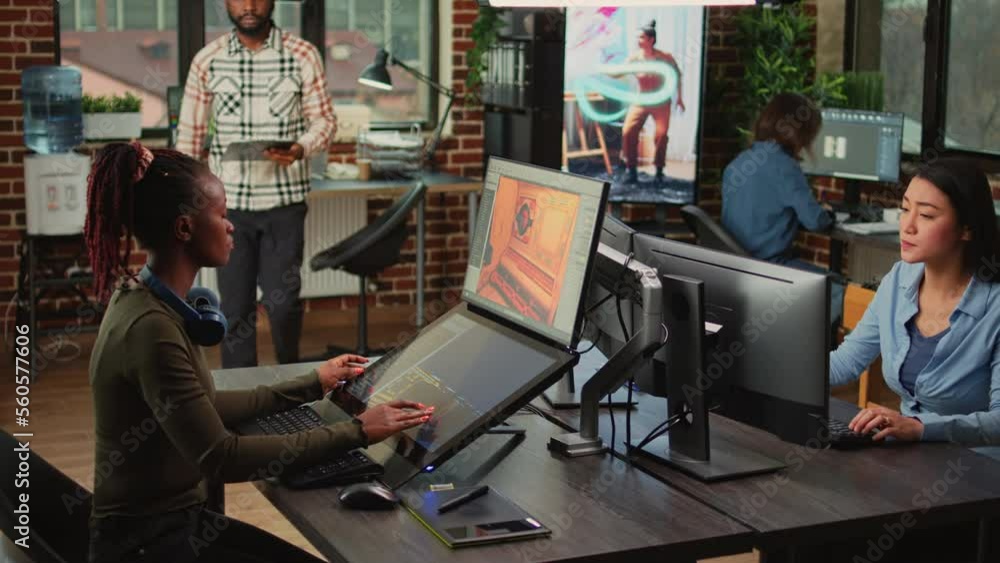 Game industry developers working on artistic development design with multiple displays on desk. Team of production department employees developing artificial intelligence technology.