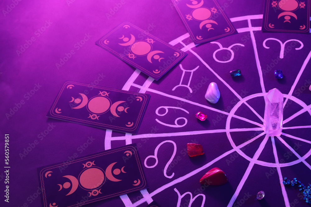 Natural stones for zodiac signs, tarot cards and drawn astrology chart on purple background. Color tone effect Natural stones for zodiac signs, tarot cards and drawn astrology chart on purple background. Color tone effect