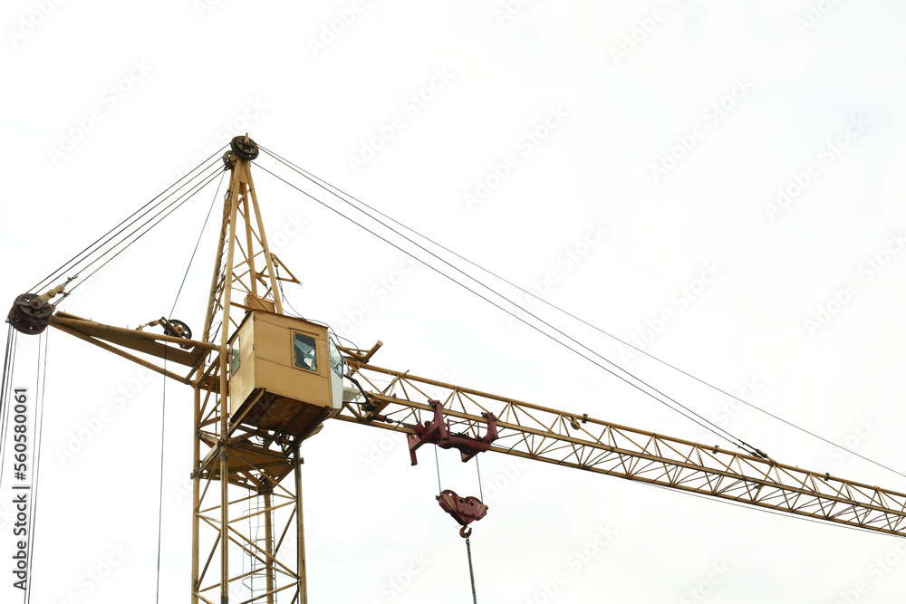 Tower crane under cloudy sky, low angle view. Construction site