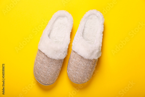Pair of beautiful soft slippers on yellow background, top view