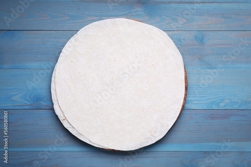 Delicious thin Armenian lavash on light blue wooden table, top view