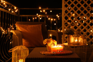 Beautiful view of garden furniture with pillow and burning candles at balcony