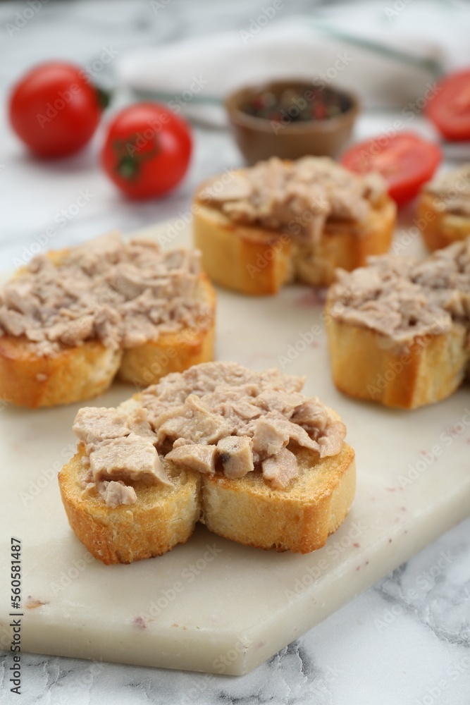 Tasty sandwiches with cod liver on white marble table