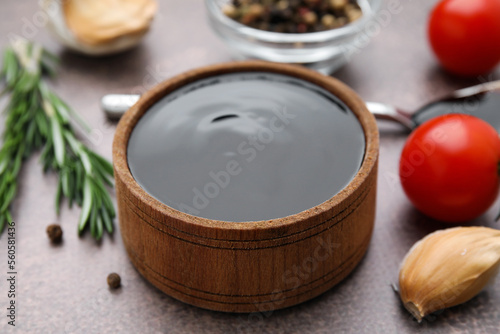 Organic balsamic vinegar and cooking ingredients on grey table, closeup