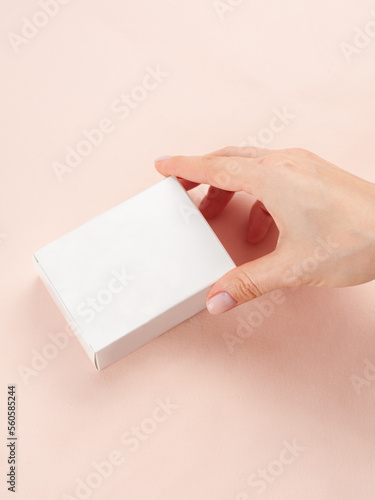 Blank White Product Package Box Mock-up. In a female hand. Container, Packaging Template on white .White cardboard box.
