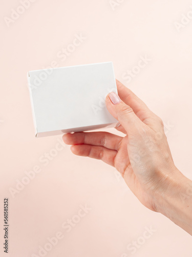 Blank White Product Package Box Mock-up. In a female hand. Container, Packaging Template on white .White cardboard box.
