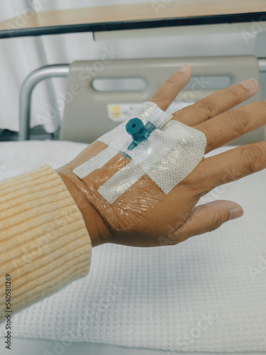 Focus on the hand of a patient in hospital ward