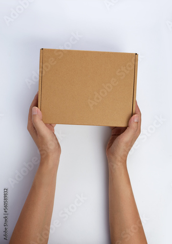 Top view hand holding a cardboard parcel isolated on white. © runrun2
