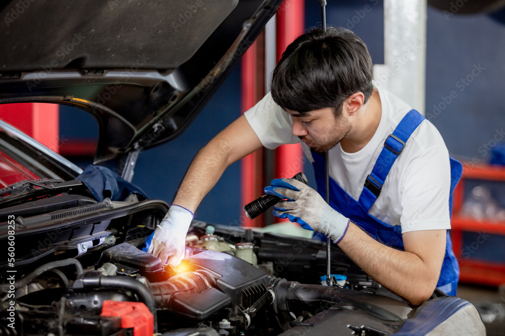 Transportation repair service concept, Repairman auto mechanic using flashlight to check for damage inside engine. man worker service engine mechanic garage. Transportation repair service concept, Repairman auto mechanic using flashlight to check for damage inside engine. man worker service engine mechanic garage.