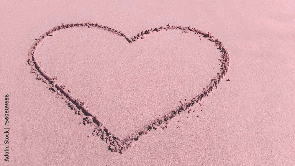 heart painted with a finger on the beach on the sand, place in the center for text