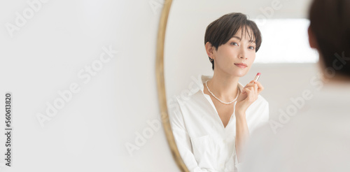 Fotografiet 鏡の前でメイク直しをするアジア人女性