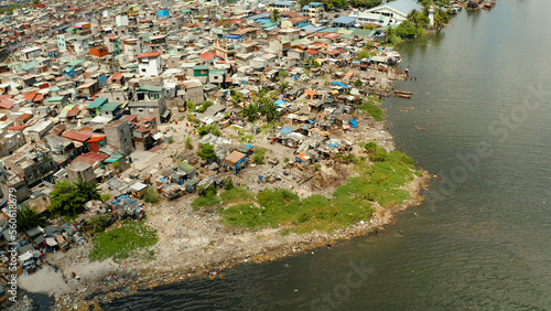 Slums near the port in Manila on the bank of a river polluted with garbage, aerial view. photo