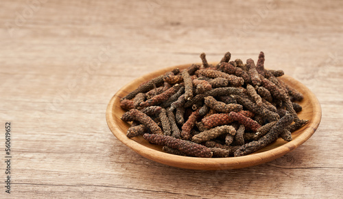 long pepper or piper longum in wood plate on wood table background. heap of long pepper or piper longum. long pepper, piper longum 