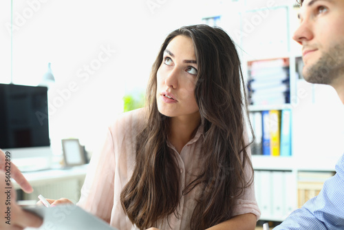 Foto Young male and female interns look up at boss in office