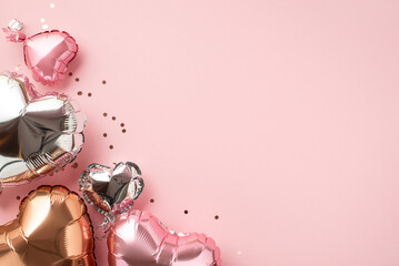 Saint Valentine's Day decor concept. Top view photo of heart shaped pink silver golden balloons and glowing confetti on isolated patel pink background with empty space