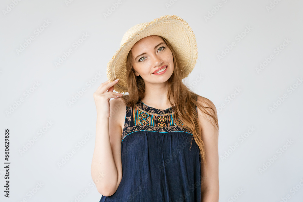 Portrait pretty blonde woman on light gray studio background. Confident sunny outfit with a straw hat cute smiling caucasian girl. Portrait pretty blonde woman on light gray studio background. Confident sunny outfit with a straw hat cute smiling caucasian girl.