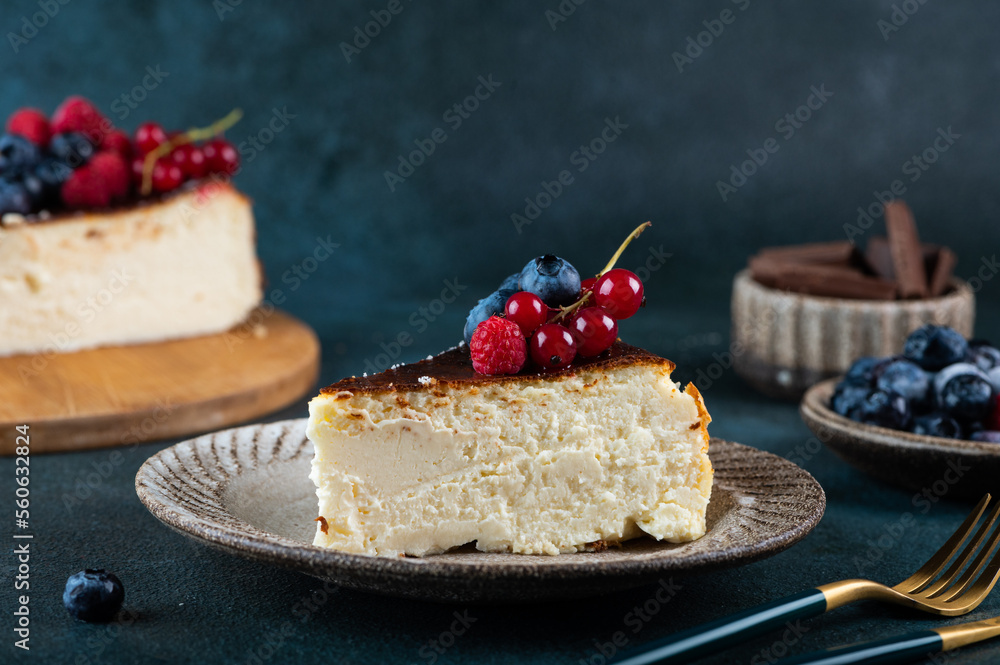 Obraz premium Piece of San Sebastian Basque Cheesecake with berries. Basque cheesecake. Popular dessert. Burnt cheesecake.