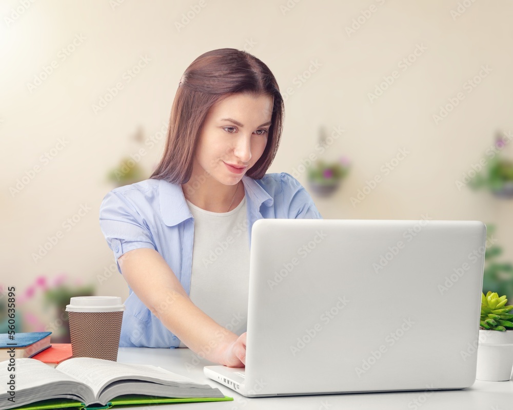 Serious young businesswoman sitting at work in office on laptop Serious young businesswoman sitting at work in office on laptop