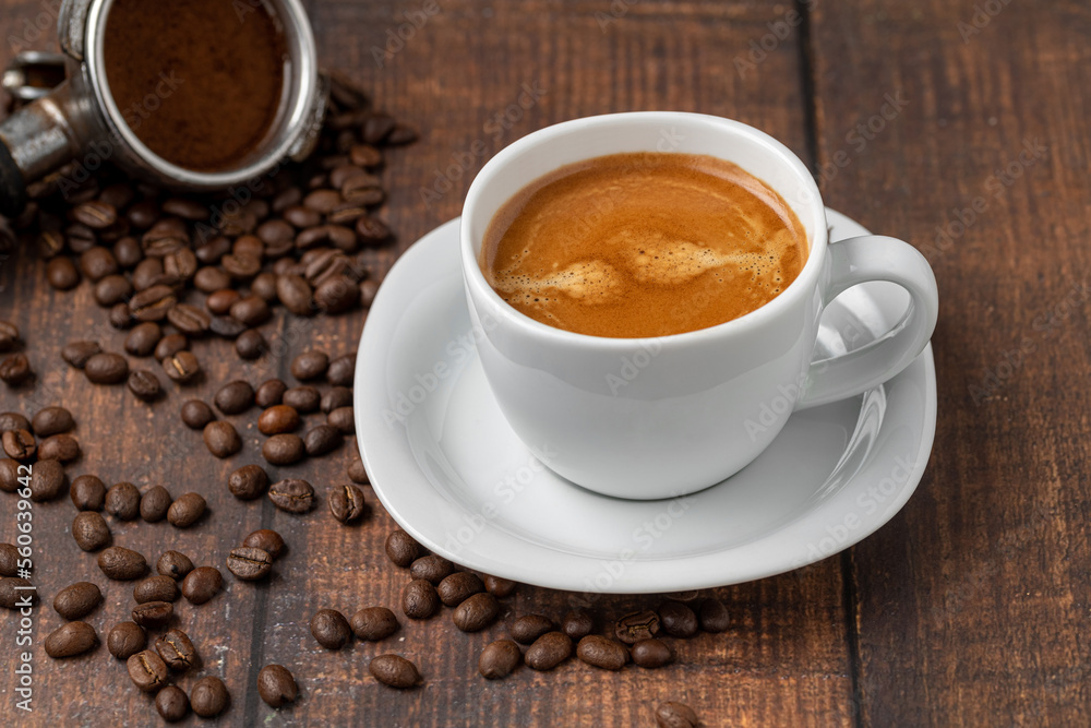 Fresh double espresso coffee and coffee beans on wooden table Fresh double espresso coffee and coffee beans on wooden table